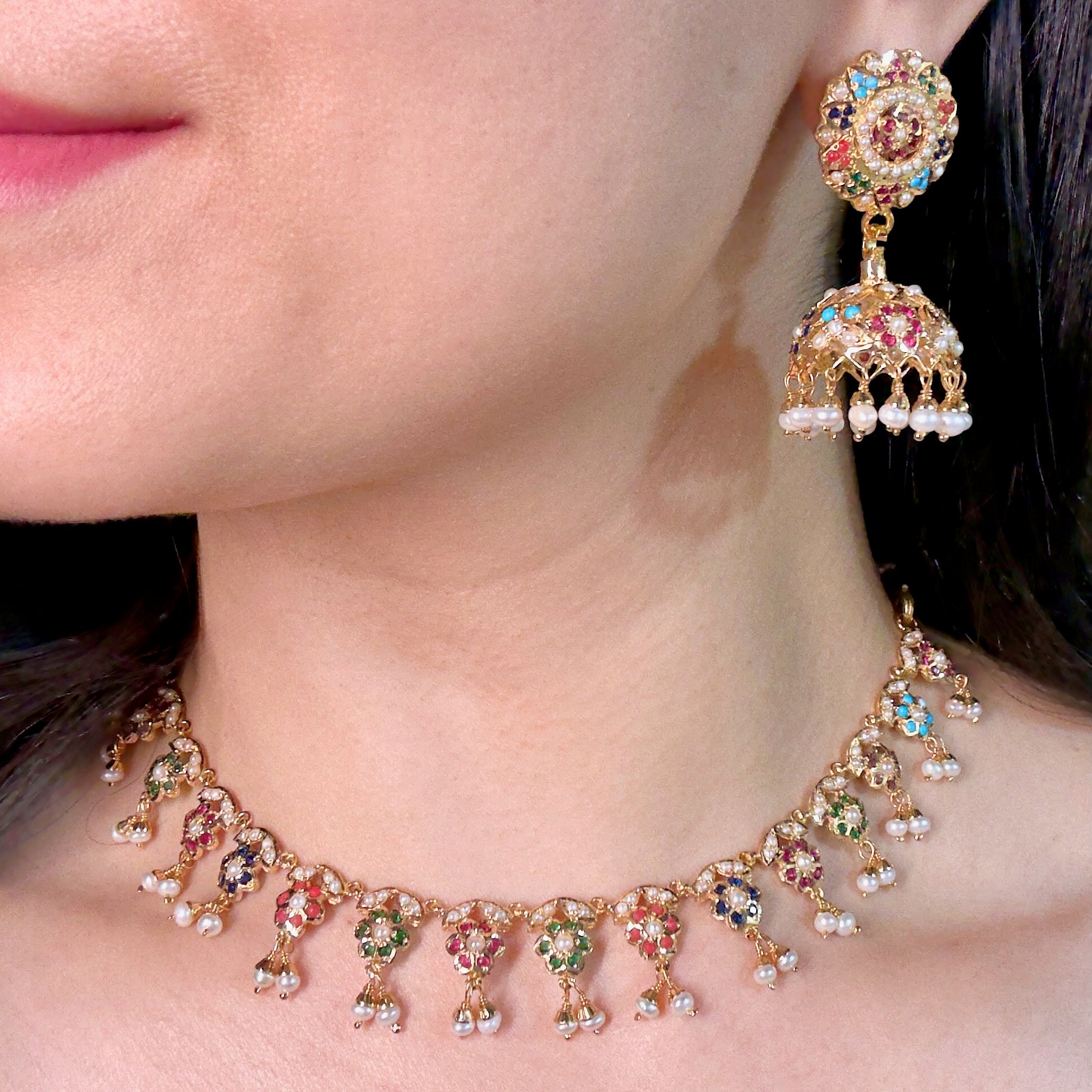 Close-up of a woman wearing a colorful necklace and earrings.