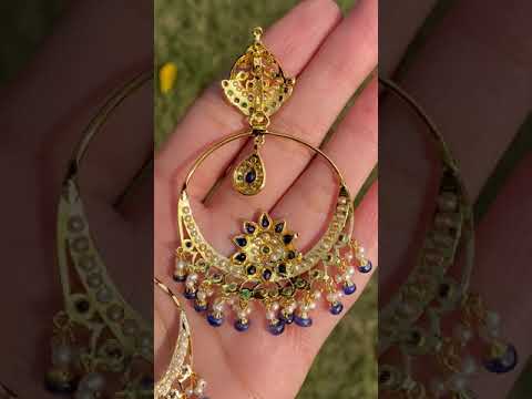 gold chandbali earrings studded with pearls emeralds and blue sapphires