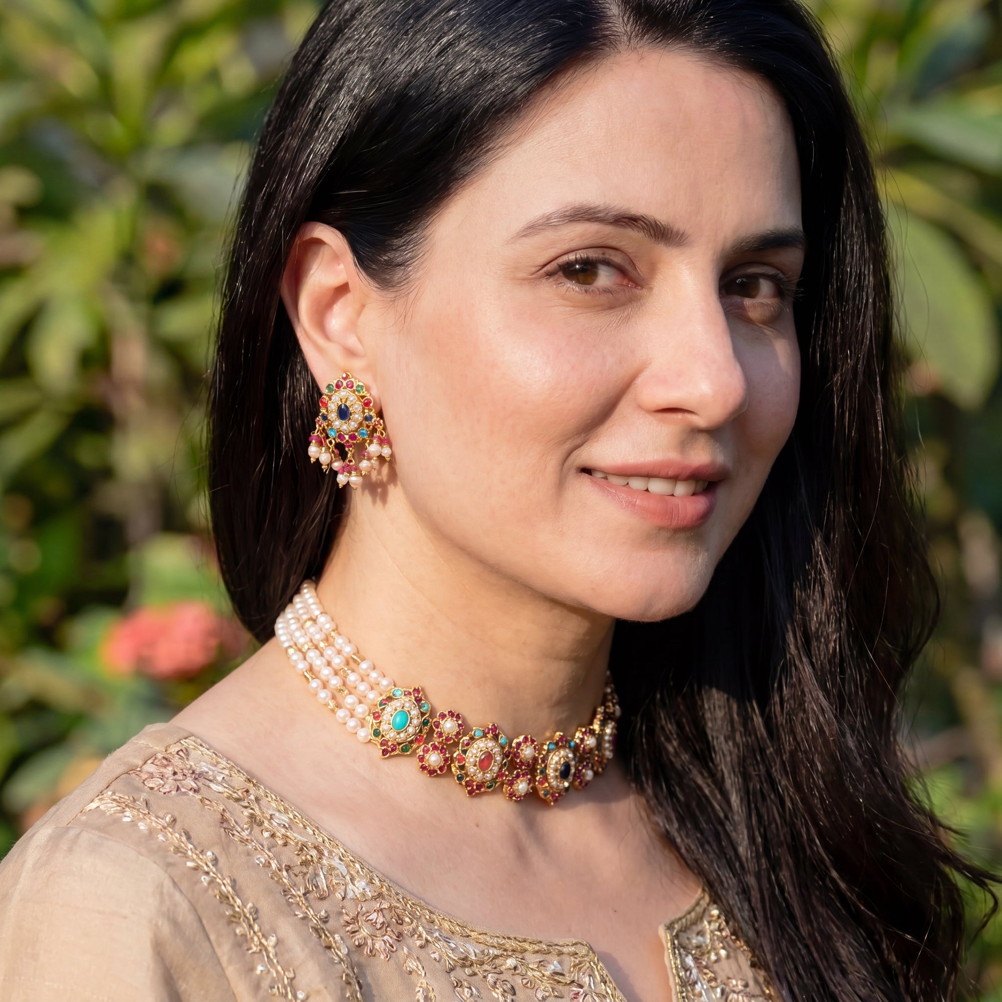 bengali Woman wearing traditional jewelry with a blurred green background