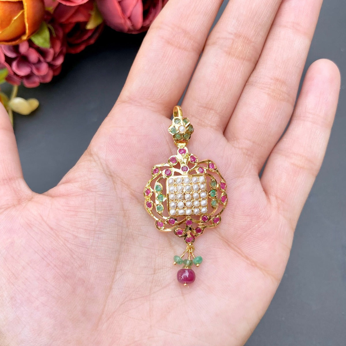 small gold pendant with ruby emerald