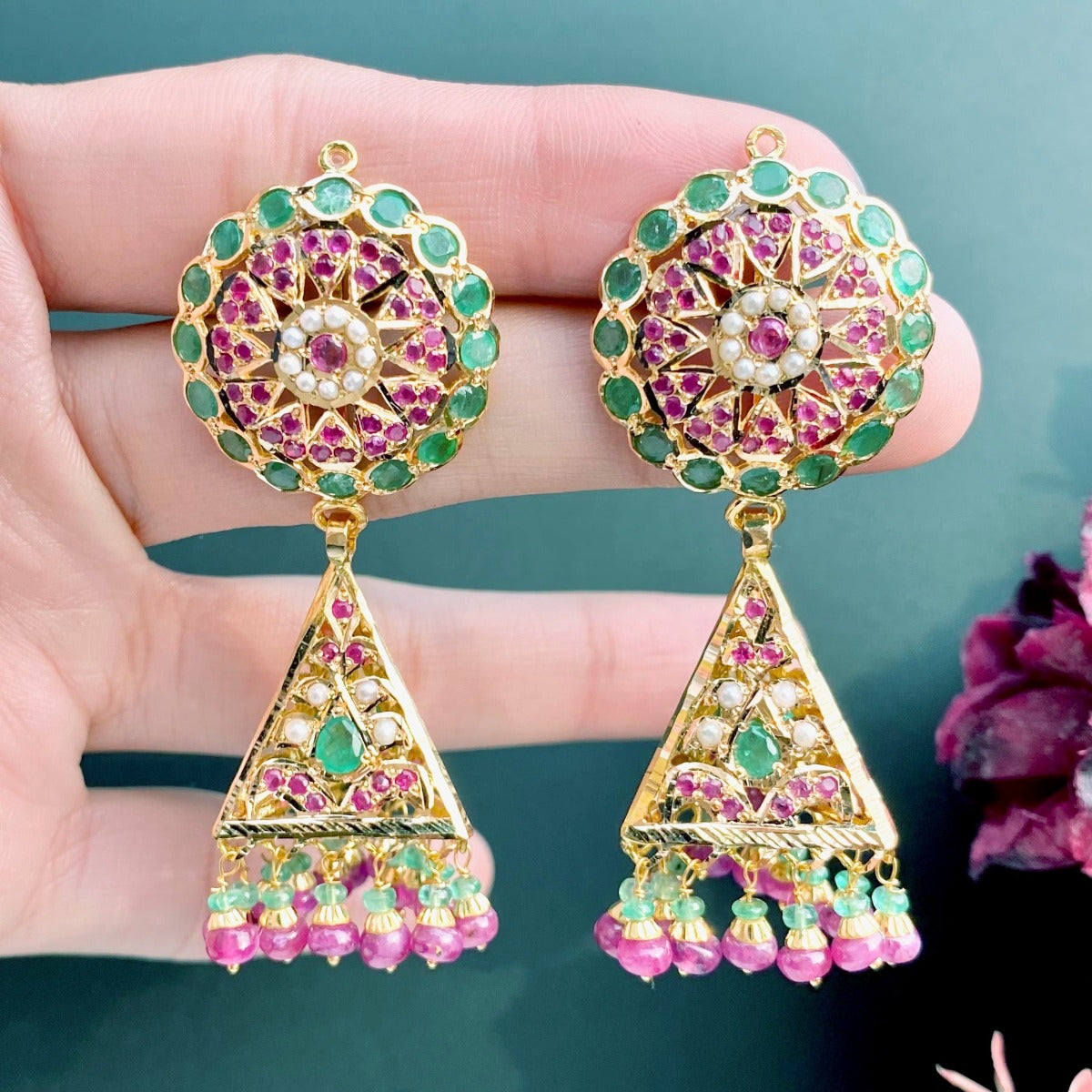 gold jhumka studded with emeralds and rubies